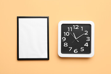 Stylish clock and blank frame on color background