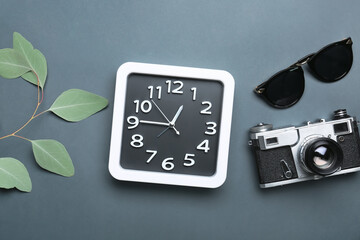 Composition with stylish clock and photo camera on grey background