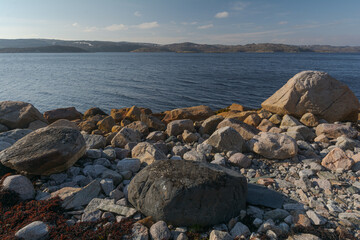 Fototapeta na wymiar The shore of the bay and many large stones .