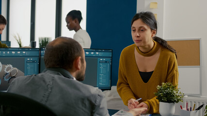 Industrial architect colleagues working and having fun sharing ideas for new mechanical project. Engineers using pc with CAD software and two monitors in start up company innovating motor prototype.