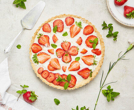 Strawberry cake with coconut sprinkles and mint on a light background