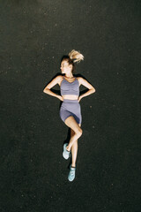 A sporty woman trains and exercises at a fitness stadium. Warm-up in the open air, stretching.