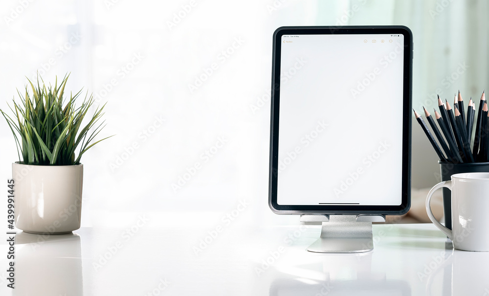 Poster mockup blank screen tablet in vertical view on white table with copy space.