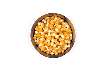 Yellow dried corn kernels in a wooden cup on white background.