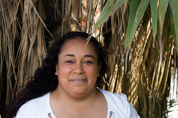 portrait of beautiful indigenous Mexican woman smiling among palm trees in the jungle