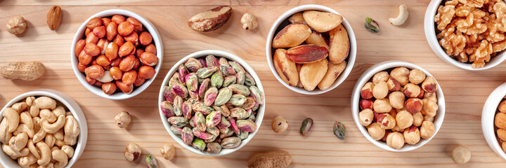 Nuts panorama with pistachios, peanuts, cashews and many other nuts, top shot