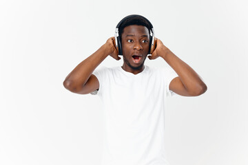 man of african appearance in headphones in a white t-shirt listening to music entertainment