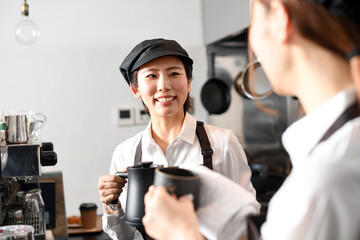  飲食店で働くエプロン姿の女性達