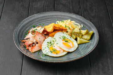 Fried eggs, ham with potato wedges, pickled cabbage and cucumber