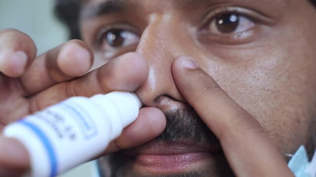 Head shot of young little child with medical face mask getting Intranasal Coronvirus covid-19 vaccination or jab through nostril from doctor - concept of covid nasal vaccine.