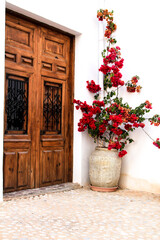 Whitewashed facade with old wooden door and bougainvillea in Altea