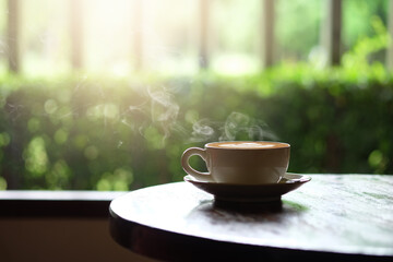Hot coffee on a wooden table on the terrace.