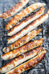 Food background. Bbq sausages on the charcoal grill. Grilled Bratwurst, close up, selective focus.