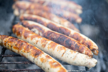 Food background. Bbq sausages on the charcoal grill. Grilled Bratwurst, close up, selective focus.