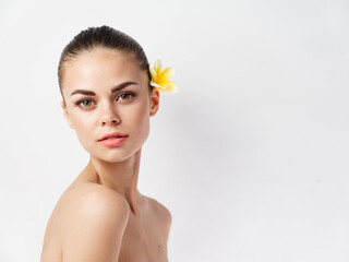Fototapeta premium pretty woman with bare shoulders face makeup skin care yellow flower