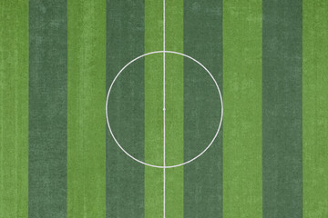 Aerial top view of the green grass texture of the circular area in the center of the soccer field