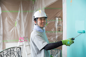 笑顔の若い日本人の塗装業、視線有、仕事中の横顔 - obrazy, fototapety, plakaty