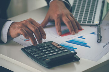 Close up business man hands using calculator counting tax financial bill. Man hands calculating number, data, graph, chart audit planning accountancy on business report. Tax audit Finacial concept.