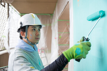 笑顔の若い日本人の塗装業、視線有、仕事中の横顔