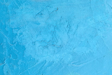 Abstract blue background with texture of concrete wall with plaster stains.