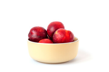 Ripe red peaches in a bowl isolated on white. Close up