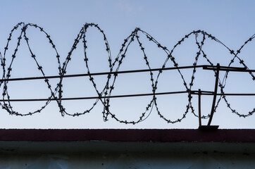 Fence and barbed wire against the sky