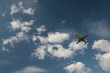 airplane flying over cloudy blue sky