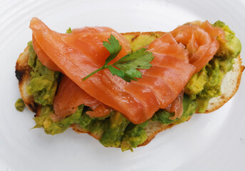 Tasty meal of smashed avocado and smoked salmon on bread