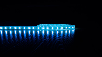 blue shining led strip light on dark background with copy space.