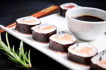 Close-up of plate with sushi and bowl of soy sauce. Asian food. Healthy food concept