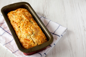 Homemade Cheesy Bread Loaf on a white wooden background, side view. Copy space.