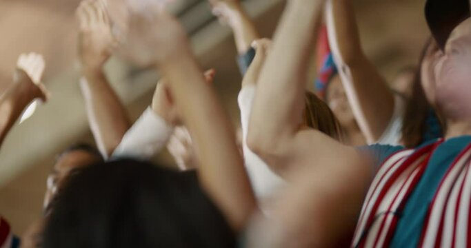 Excited fans in sports crowd cheering on their team