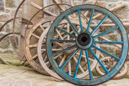 Vieilles roues en bois de véhicules agricoles dans une cour de ferme