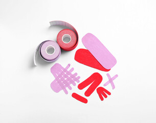 Different kinesio tape pieces and rolls on light blue background, flat lay