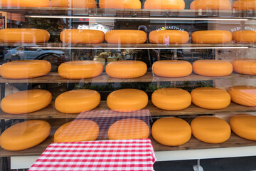Malmo, Sweden June 12, 2021 The window of a cheese shop with large gouda cheeses in the window.