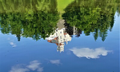 Castle by the lake in green nature landscape