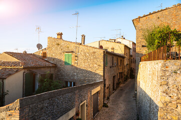 Volterra, Tuscany, Italy. August 2020. The characteristic alleys of the historic village. Street and houses made of stone have a medieval flavor, the warm late afternoon light envelops the scene.