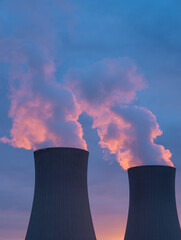 Nuclear power plant against sky at sunset