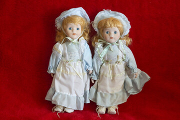 Closeup shot of two vintage dolls on a red background