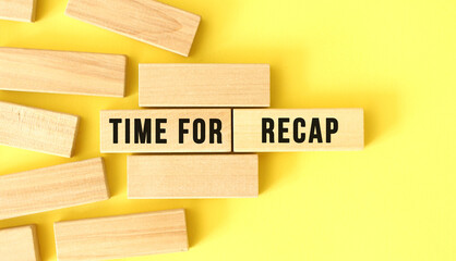 TIME FOR RECAP text written on a wooden blocks on a yellow background.