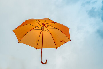 Yellow umbrella in the sky. Sunny umbrella in the sky, creating a summer, artistic mood on the street.