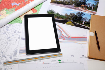 Urbanisme - Aménagement du territoire - Tablette numérique posée sur des cartes et plan de masse d'un projet de voirie et giratoire