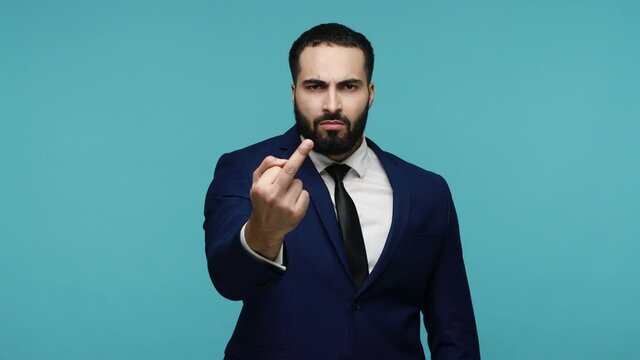 Aggressive businessman with beard showing, demonstrating protest hate with impolite rude gesture of disrespect, negative face expression. Indoor studio shot isolated on blue background.