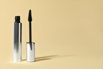 Mascara on beige background, space for text