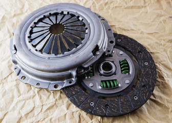 Car spare parts. Car clutch kit. Clutch disc, basket and clutch bearing. Car repair kit clutch manual gearbox on a background of craft paper.