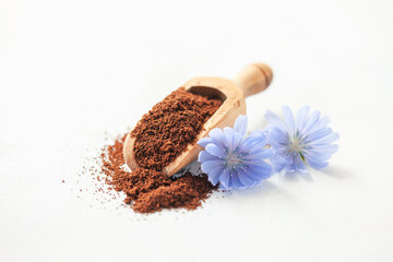 Diet drink chicory in a cup - coffee substitutes, powder and flowers on the white background.