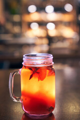 Close up of red drink non-alcoholic mulled wine with a straw on the background of the cafe interior, order for one