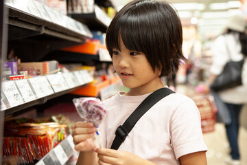 スーパーマーケットでキャンディを選ぶ女の子