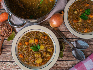 vegetarian lentil soup  with root vegetables and potatoes on rustic table background