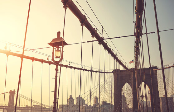 Retro stylized picture of Brooklyn Bridge at sunrise, New York City, USA